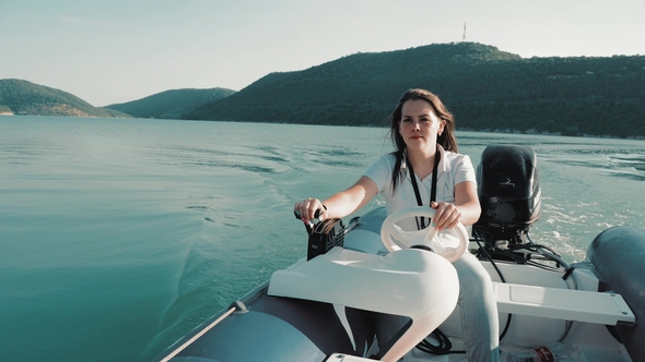 Summer Vacation - Young Girl Driving a Motor Boat alt
