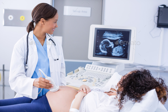 Doctor doing ultrasound scan for pregnant woman Stock Photo by  Wavebreakmedia