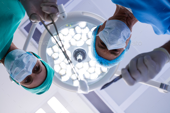 Surgeons performing operation in operation theater - Stock Photo - Images