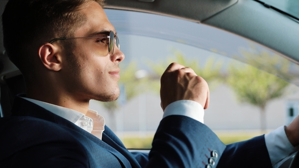 Young Successful Businessman Takes Off His Sunglasses and Looking Into the Camera