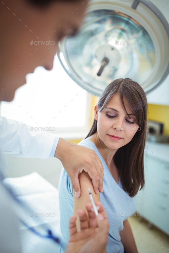 Doctor giving an injection to the patient Stock Photo by Wavebreakmedia