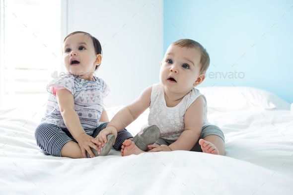 Two cute baby girls relaxing on bed Stock Photo by Wavebreakmedia | PhotoDune