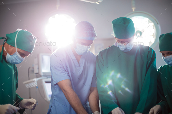 Medical team performing operation in a operating room - Stock Photo - Images