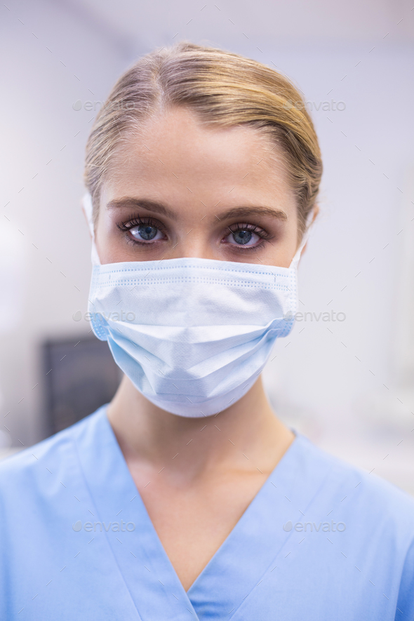 Portrait of female nurse wearing surgical mask Stock Photo by Wavebreakmedia