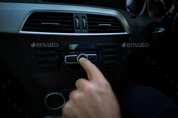 Cropped hand adjusting volume in car - Stock Photo - Images