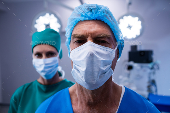 Portrait of surgeons wearing surgical mask in operation theater Stock Photo by Wavebreakmedia