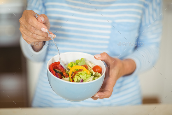 Woman holding bowl of vegetable salad Stock Photo by Wavebreakmedia