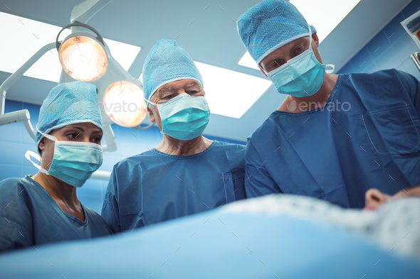 Team of surgeons performing operation in operation theater Stock Photo by Wavebreakmedia