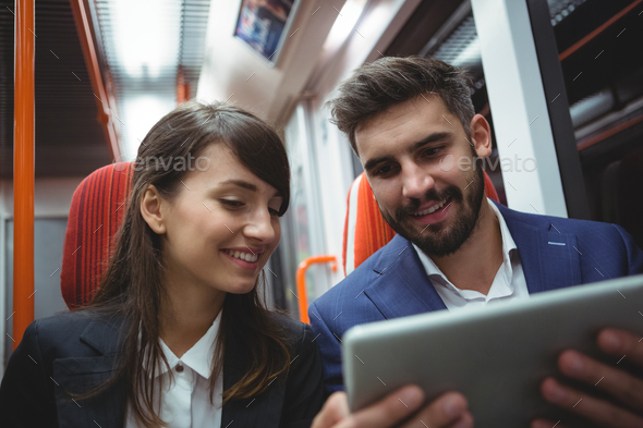 Executives using digital tablet travelling in train Stock Photo by Wavebreakmedia