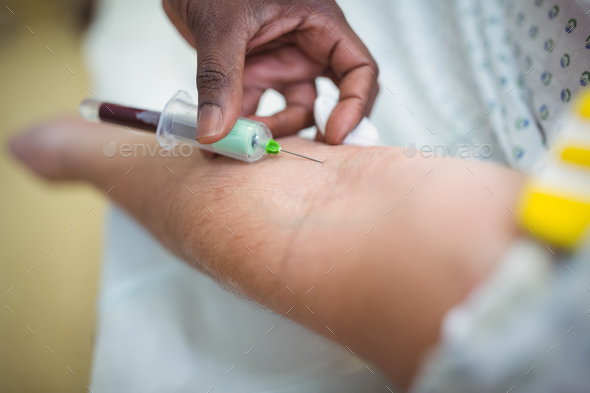 Doctor giving an injection to the patient Stock Photo by Wavebreakmedia