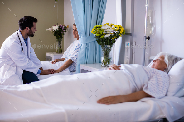 Male doctor consoling female senior patient Stock Photo by Wavebreakmedia