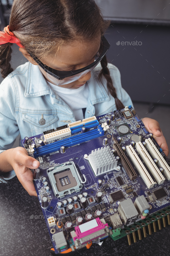 High angle view of concentrated elementary student examining circuit board Stock Photo by Wavebreakmedia