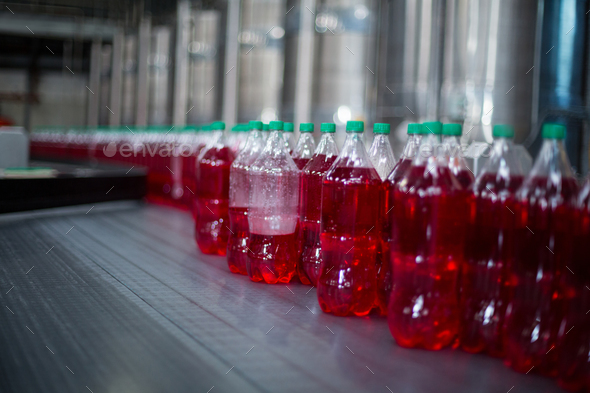 Bottles of juices processing on conveyor belt in factory Stock Photo by Wavebreakmedia