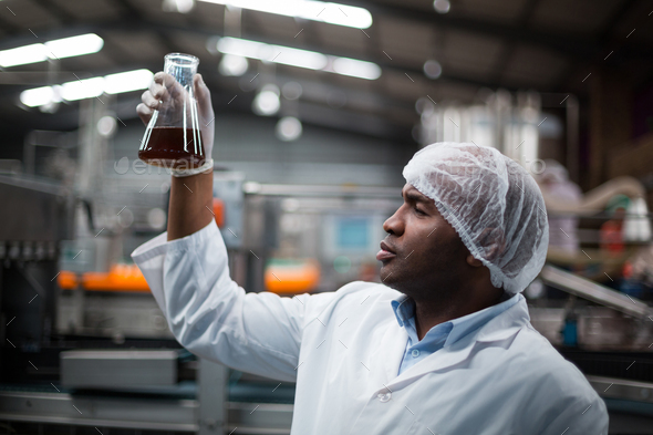 Factory engineers checking a sample of drink Stock Photo by Wavebreakmedia