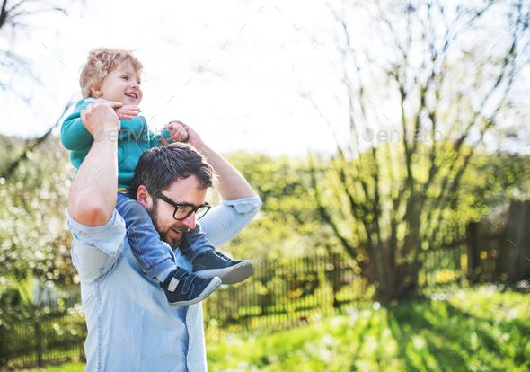 A father with his toddler son outside in spring nature. Stock Photo by halfpoint