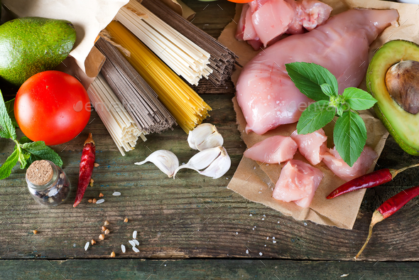 bunch of Italian spaghetti, noodles soba and sommel, chicken raw meat, avocado, zucchini with tomato - Stock Photo - Images