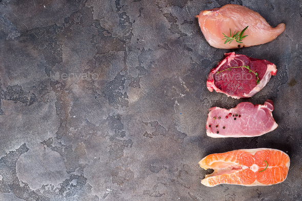 Raw chicken, meat and fish isolated on stone. Lean proteins. Stock Photo by lyulkamazur