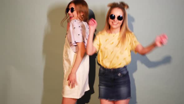 Two Carefree Young Girls Going Crazy. Women in hipster summer clothes having fun and dancing alt