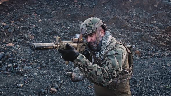A Special Forces Soldier with a Helmet on His Head Walking and Shooting From Rifle. alt