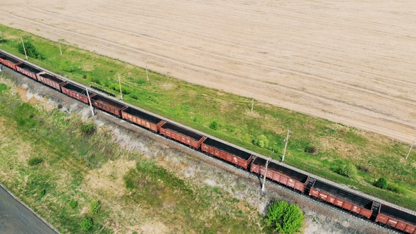 Cargo Train Moves on a Railroad, Aerial View. Freight Train with Cargo Containers Passing By alt