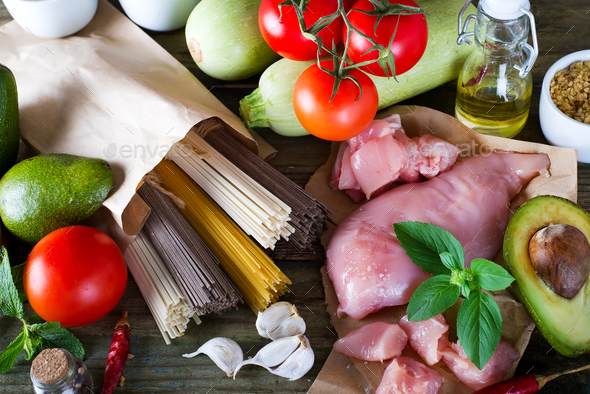 bunch of Italian spaghetti, noodles soba and sommel, chicken raw meat, avocado, zucchini with tomato - Stock Photo - Images