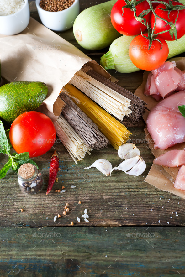 bunch of Italian spaghetti, noodles soba and sommel, chicken raw meat, avocado, zucchini with tomato - Stock Photo - Images