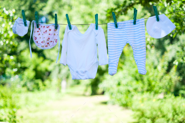 Baby clothes on clothesline in garden Stock Photo by ivankmit