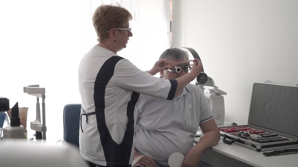 Doctor Check Man's Eyesight with Optical Trial Frame alt