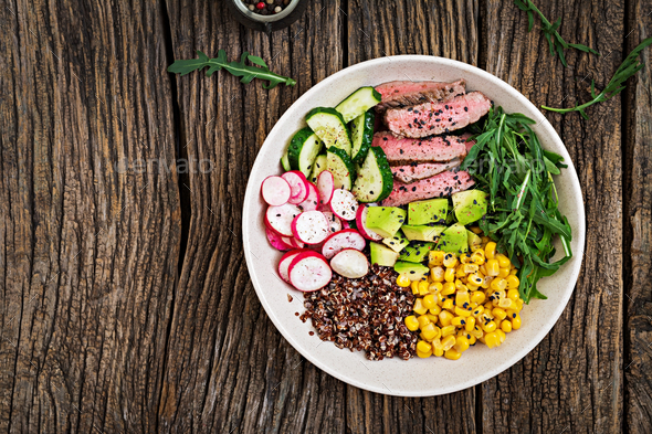 Buddha bowl lunch with grilled beef steak and quinoa, corn, avocado, cucumber - Stock Photo - Images