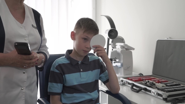Little Boy Check His Eyesight in Oculist Office alt