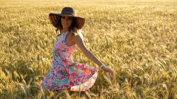 Girl with a Beautiful Summer Color Dress in a Wheat Field