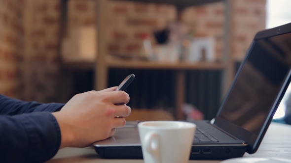 A Businessman Who Uses a Smartphone and Drinks Coffee