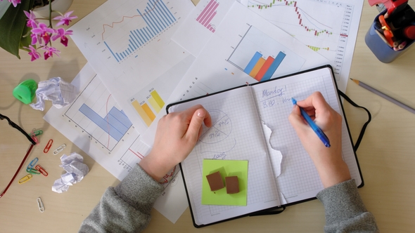 Girl Makes Notes in a Notebook, Gets Angry and Tears Out Pages. Top View. alt