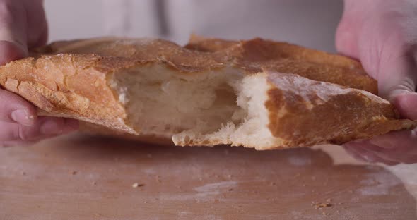 Close Up of Baker Hands Breaking Homemade Bread