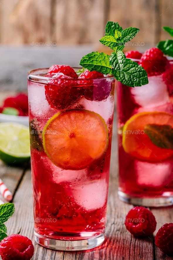 Raspberry Mojito Lemonade with lime and fresh mint in glass on wooden background - Stock Photo - Images