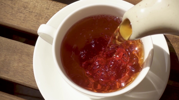 White Porcelain Cup on a Saucer on a Wooden Table with a Hot Drink