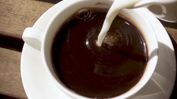 White Porcelain Cup on a Saucer on a Wooden Table with a Hot Drink