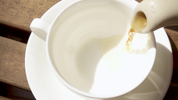 White Porcelain Cup on a Saucer on a Wooden Table with a Hot Drink