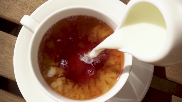 White Porcelain Cup on a Saucer on a Wooden Table with a Hot Drink