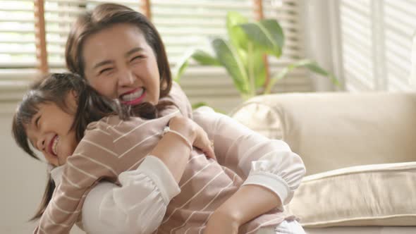 Happy little Asian Cute Girl hugging, embracing her mom
