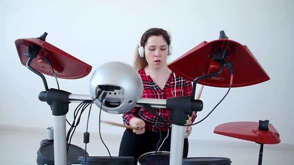 Concept of Hobby and Music. Young Woman Drummer Practicing Electronic Drum Kit at Home alt