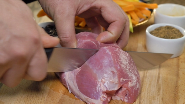 Chef Cutting the Raw Meat on a Wooden Board