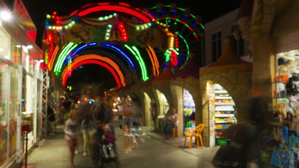 Entrance in Amusement Park at Night, People Walk and Bay Souvenirs