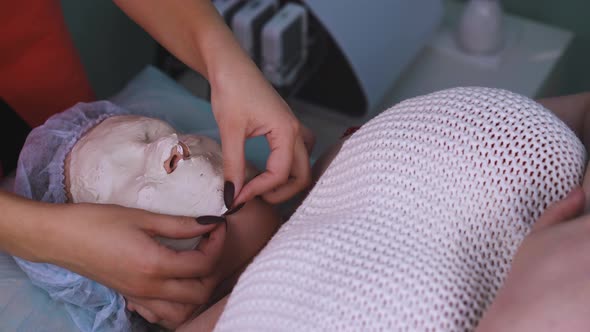 Beautician Takes Off Alginate Mask From Plussize Woman Face alt