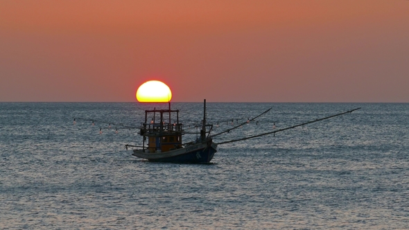 Fishing Boat in the Sea Against Setting Sun alt