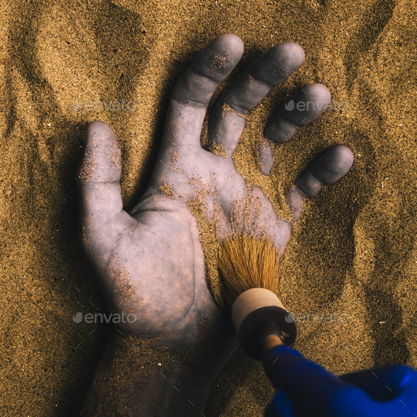 Forensic expert discovering dead body buried in desert sand - Stock Photo - Images
