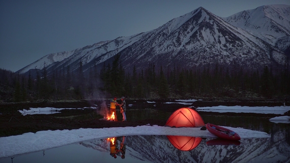 a Couple Drinking and Warming in a Camping By the Fire in Mountains alt