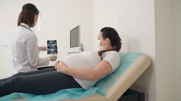 Gynecologist Showing Ultrasound Images for Pregnant Woman alt