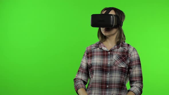 Young Woman Using VR Headset Helmet To Play Game, Showing Side Advertising Area. Chroma Key alt