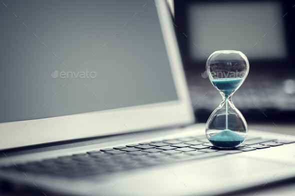 Hourglass on laptop computer concept for time management - Stock Photo - Images